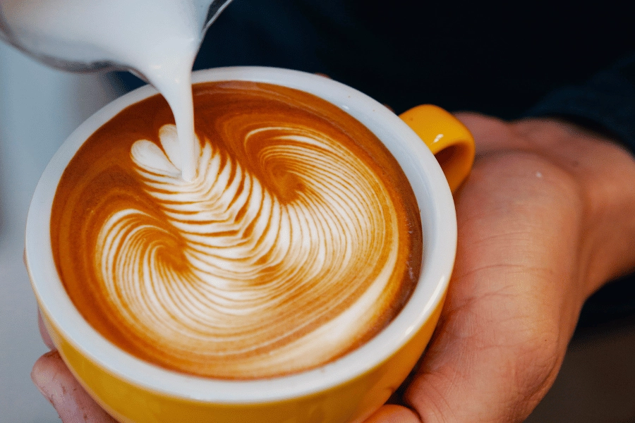 Latte art in a yellow mug of coffee